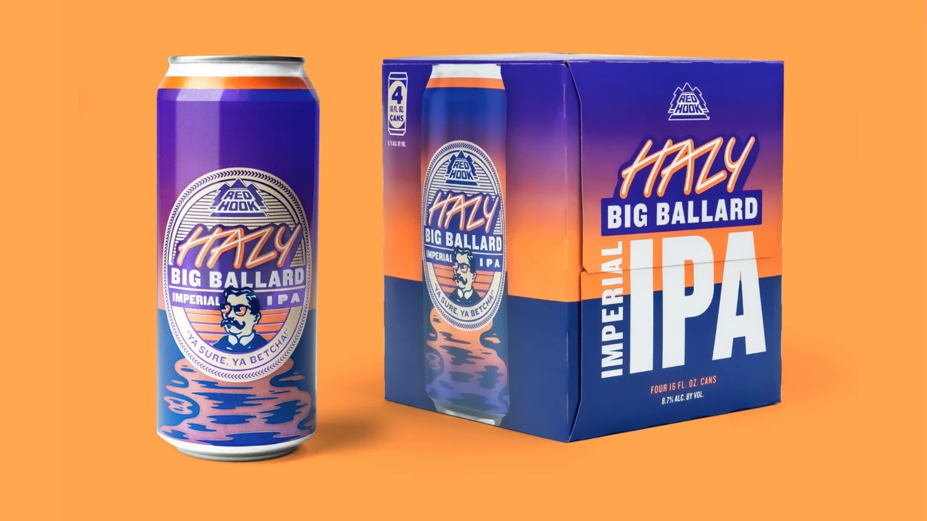 Red Hook Hazy Big Ballard Imperial IPA can and a four-pack box against an orange background. The can and box feature a gradient design with pink, purple, and orange hues, along with the Red Hook logo and a bearded man illustration. The label reads "Hazy Big Ballard Imperial IPA" with the tagline "Ya Sure, Ya Betcha!"